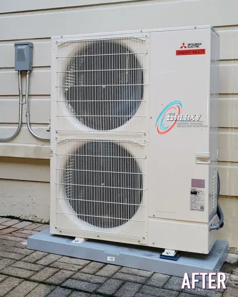 Mitsubishi Electric dual-fan heat pump on a pad beside light exterior siding in Brentwood