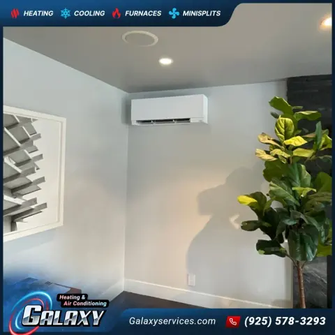 Wall-mounted mini-split above a window in a finished room with a dark accent wall in Oakland