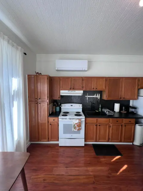Wall-mounted ductless mini-split head installed above kitchen cabinets in San Mateo