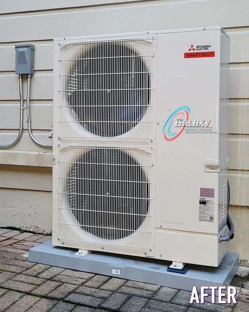Mitsubishi Electric dual-fan heat pump on a pad beside light exterior siding in Brentwood