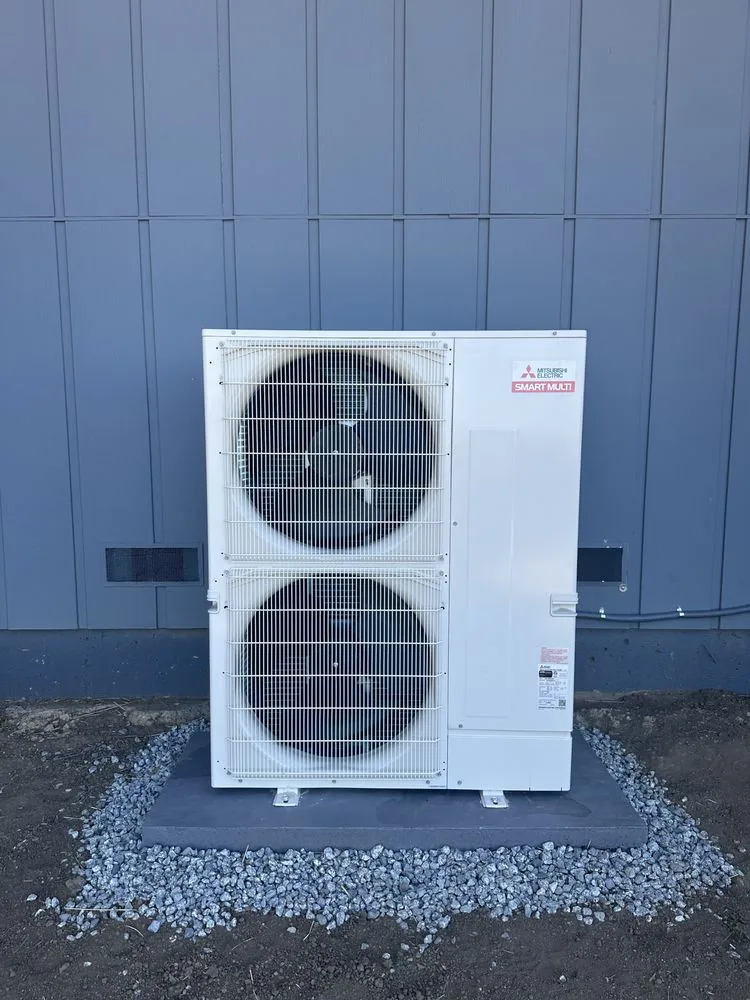 Mitsubishi Electric dual-fan outdoor unit mounted beside blue exterior siding in Orinda