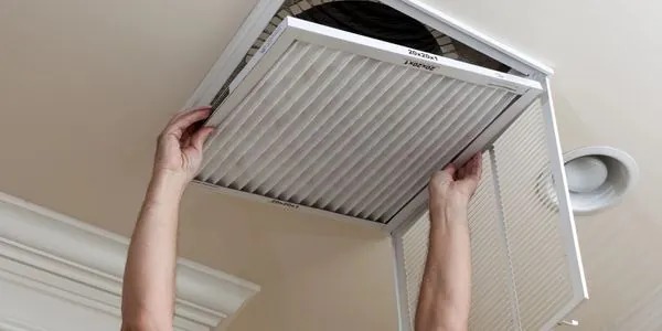 technician from galaxy heating & air conditioning performing maintenance on a heating system.